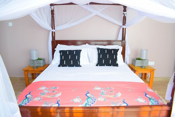 A bed with a canopy, two nightstands, and a decorative bedspread. - Ilala House, Voi - Spacious 2 Bed, 2 Bath with parking,  7 mins to Tsavo East (Voi)