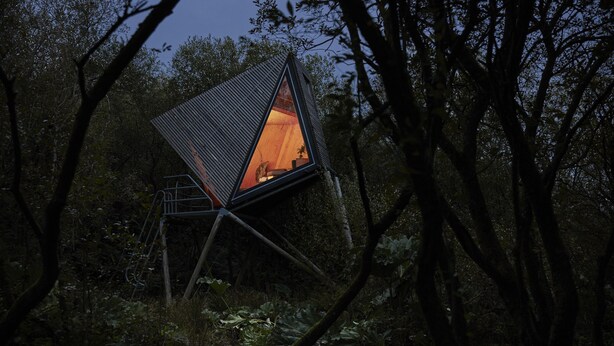 A triangular treehouse with a visible interior, surrounded by dense forest. - K2 Kudhva Treehouse Cabin for 2 in Tintagel (Tintagel)