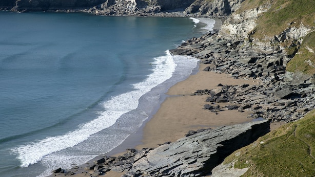 A coastal landscape with a rocky beach, cliffs, and a clear view of the sea. - Black Shanti Tipi 2 With Ocean View (Tintagel)