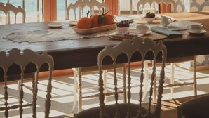 A dining area with a view of the sea, wooden furniture, and a patterned wall. - La Balza di Scilla (Scilla)