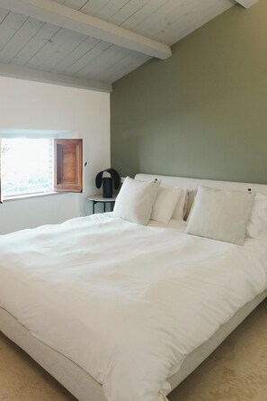 A large bed with white bedding, a wooden ceiling, a green wall, and a window with blinds. - La Balza di Scilla (Scilla)