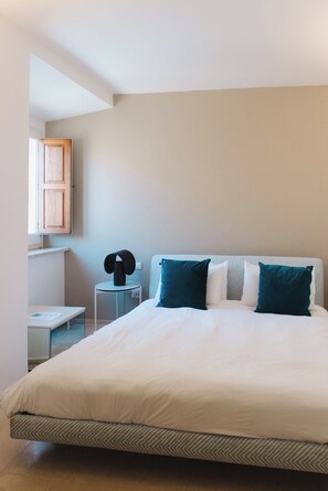 A bedroom with a large bed, a bedside table, a chair, and a wall-mounted cabinet. - La Balza di Scilla (Scilla)