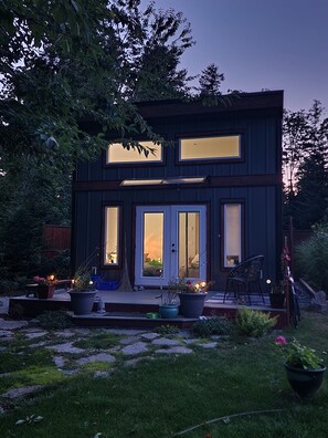 Ein modernes, zweistöckiges Haus mit großen Fenstern und einer Haustür.