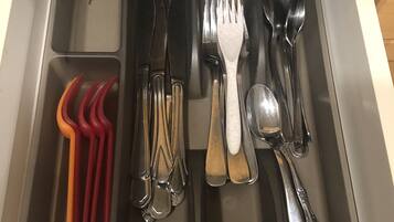 Un tiroir contenant des ustensiles de cuisine et des couverts.