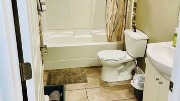 A bathroom with a bathtub, toilet, and sink.