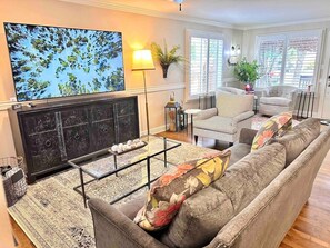 A living room with a fireplace, a sofa, a striped armchair, and a television. - Pleasant Downtown Haven *0.3 Miles *Pet Friendly (Prescott)