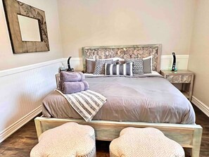 A bedroom with a large bed, two nightstands, a headboard, and two ottomans. - Pleasant Downtown Haven *0.3 Miles *Pet Friendly (Prescott)