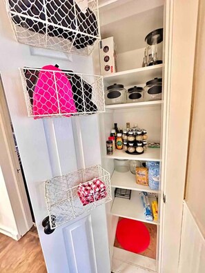 A storage area with shelves containing kitchenware, spices, and cleaning supplies. - Pleasant Downtown Haven *0.3 Miles *Pet Friendly (Prescott)