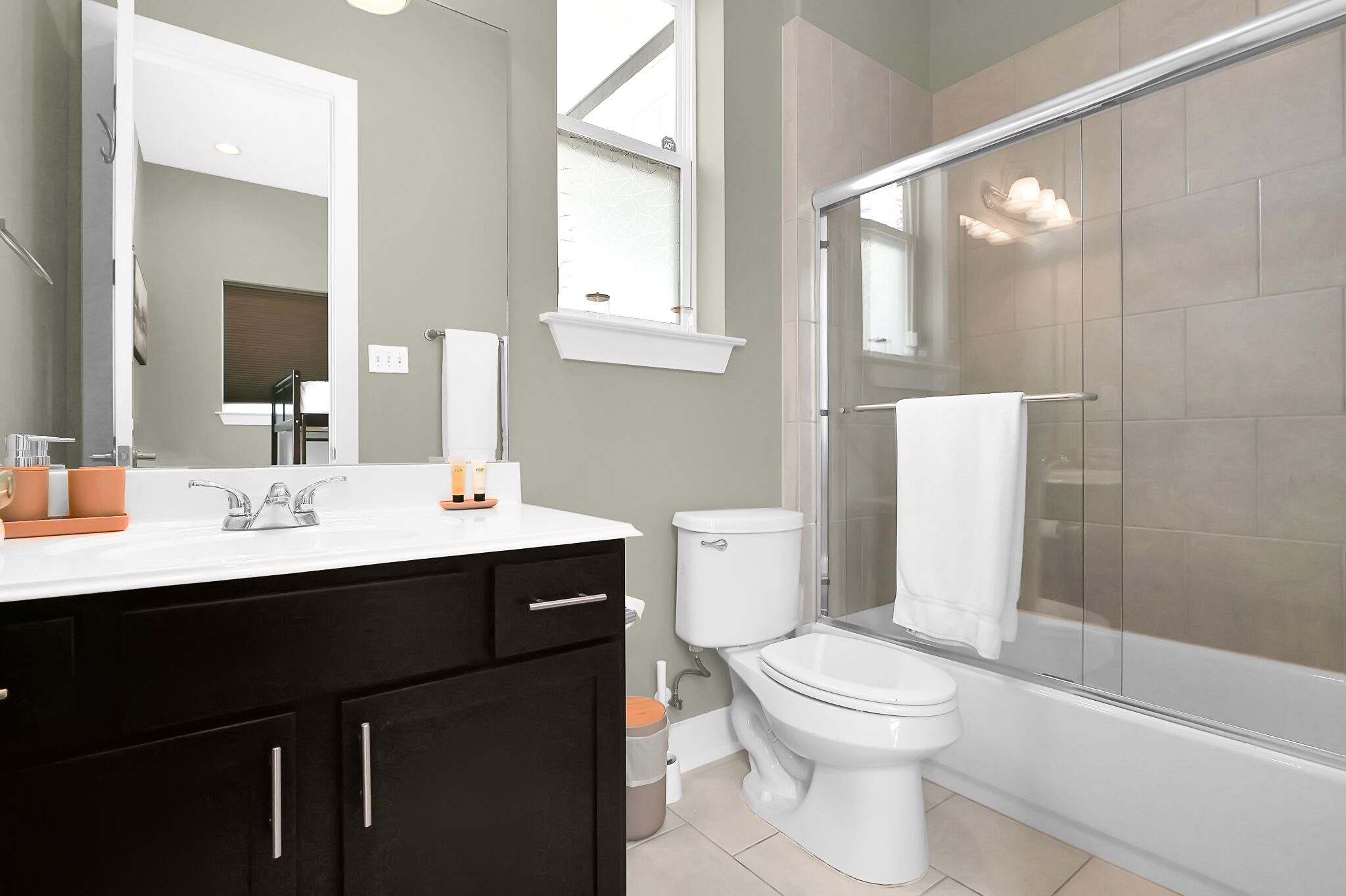 Een moderne badkamer met douche, toilet en wastafel.