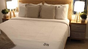 A neatly arranged bedroom with a large bed, bedside tables, and wall-mounted lamps. - Peaceful One Bedroom Residence with Parking (Brisbane)