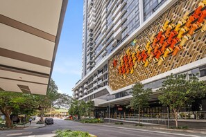 A modern building with a unique facade featuring geometric patterns and a large entrance area.