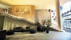 A spacious lobby with a modern staircase, seating area, and large windows. - Two Bedroom Two Bathroom | First Class Residence on Queen St, Brisbane CBD (Brisbane)
