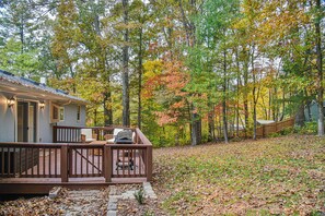 Une maison dotée d’une terrasse, entourée d’arbres aux feuilles d’automne.
