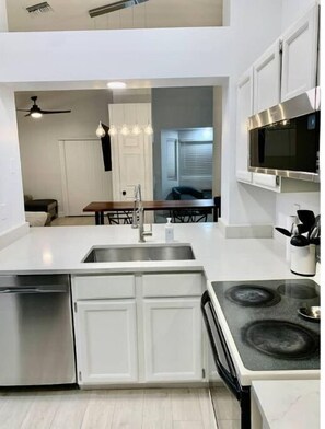 Enjoy cooking in this well-equipped kitchen with a central island, sink, stove, and dishwasher.