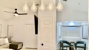 A modern living room with a sofa, a coffee table, and a ceiling fan. There are five pendant lights hanging from the ceiling. - Cortaro Sweet Home-Quiet gated community  (Tucson)
