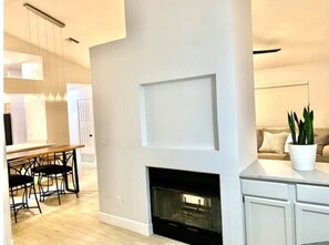 Cozy living space with a central fireplace and dining area.