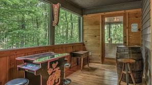 A wooden room with a Pac-Man arcade game, a wooden door labeled "Arcade," and a barrel. - Casa Azul - Secluded, Modern, Arcade, Hot Tub, Dogs Welcome! (Blue Ridge)