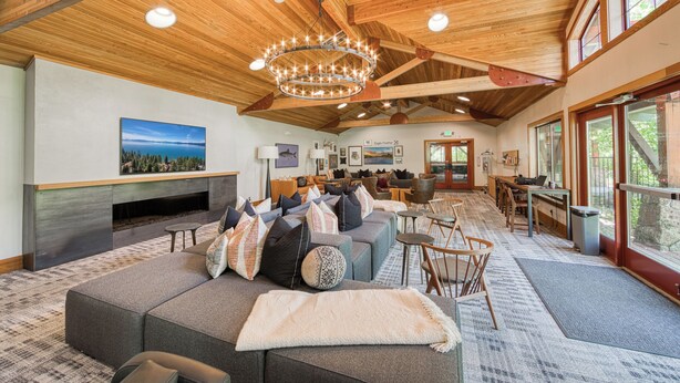 A spacious living area with a large sectional sofa, a fireplace, and a dining area with wooden tables and chairs.