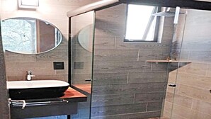 A modern bathroom with a glass-enclosed shower, a wooden vanity, and a large mirror. - Loft Tree House 1 by Kivoya (Zapopan)