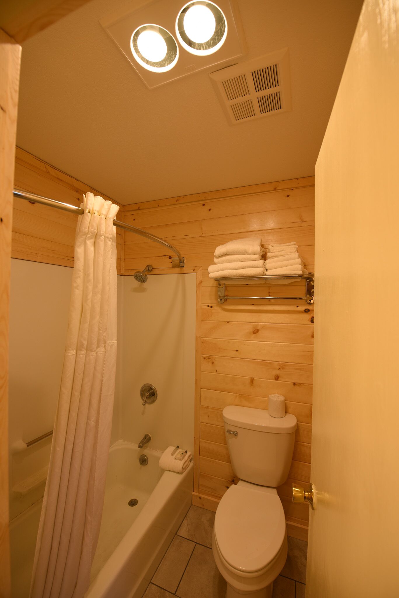 Een kleine badkamer met een douche, toilet en een handdoekhouder.