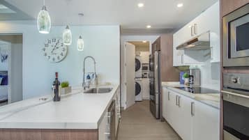A modern kitchen with a central island, stainless steel appliances, and pendant lighting.