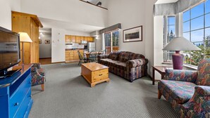 Ein geräumiges Wohnzimmer mit einer Couch, einem Sessel und einer Holzkommode.