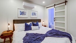 A neatly arranged bedroom with a bed, bedside tables, and wall-mounted artwork.
