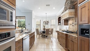 A spacious kitchen with modern appliances, a dining area, and a stone accent wall.