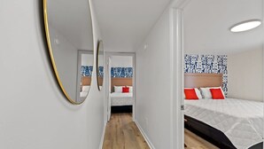 Ein modernes Schlafzimmer mit einem großen Bett, einem Nachttisch und einem Spiegel.
