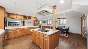 A spacious kitchen with wooden cabinets, a central island, and a dining area with a table and chairs.