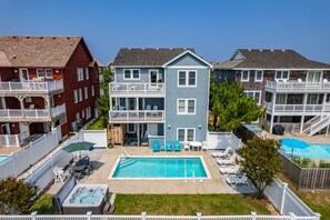 Área residencial com piscina, espaço para sentar ao ar livre e ofurô.