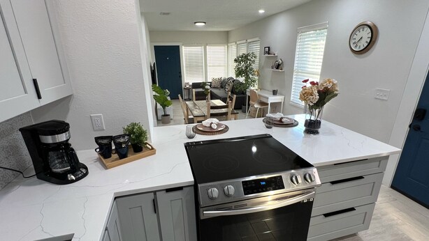 A modern kitchen with a built-in stove, oven, and coffee maker. - Luxury StayComfy at WinterHeaven (Winter Haven)
