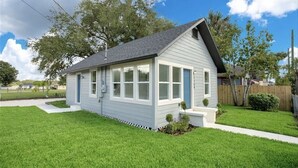 A single-story house with a gabled roof, a front porch, and a small front yard. - Luxury StayComfy at WinterHeaven (Winter Haven)