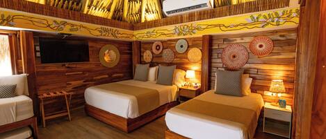 A room with two beds, a TV, and a wooden ceiling.