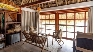 A room with a thatched roof, wooden furniture, and large windows. - Hotel Isla del Sol  (Rosario Islands)