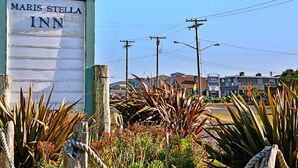 A Maris Stella Inn sign with a rustic wooden fence and tropical plants in the foreground.