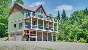 Ein zweigeschossiges Haus mit Balkon, Garage und überdachter Veranda.