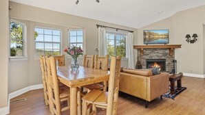 Un coin repas avec une table et des chaises en bois, une cheminée et un canapé.