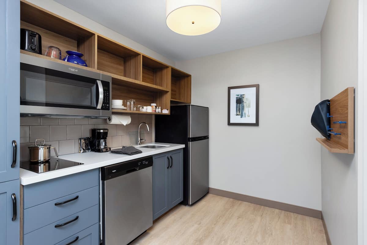 A compact kitchen with a microwave, coffee maker, and a dishwasher.