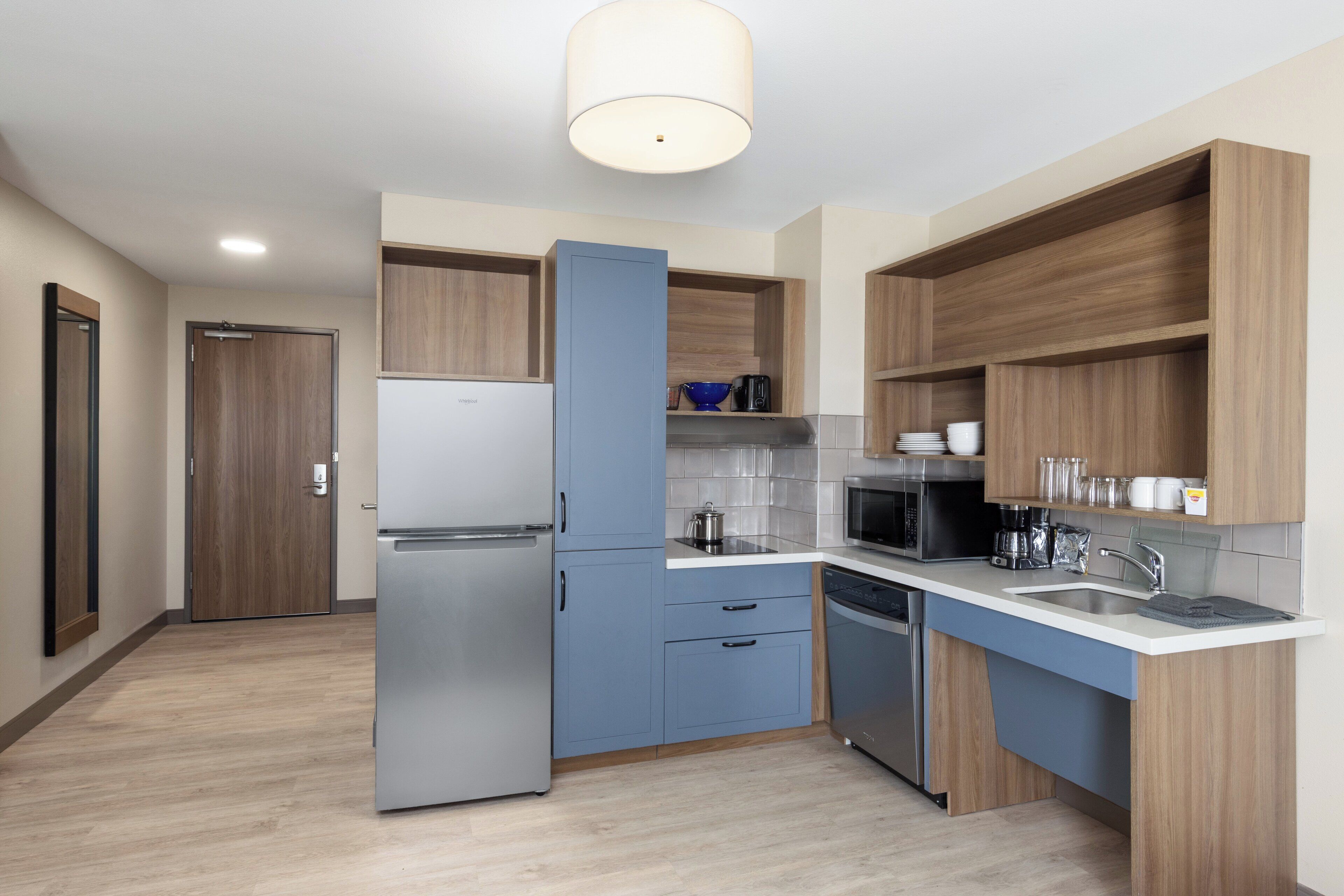 A modern kitchen with a built-in refrigerator, microwave, and dishwasher.