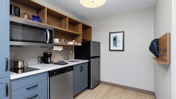 Cocina compacta con microondas, cafetera y lavavajillas.