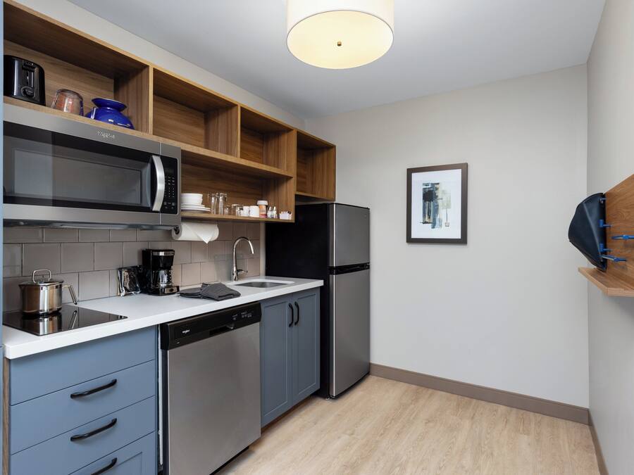 Cocina compacta con microondas, cafetera y lavavajillas.