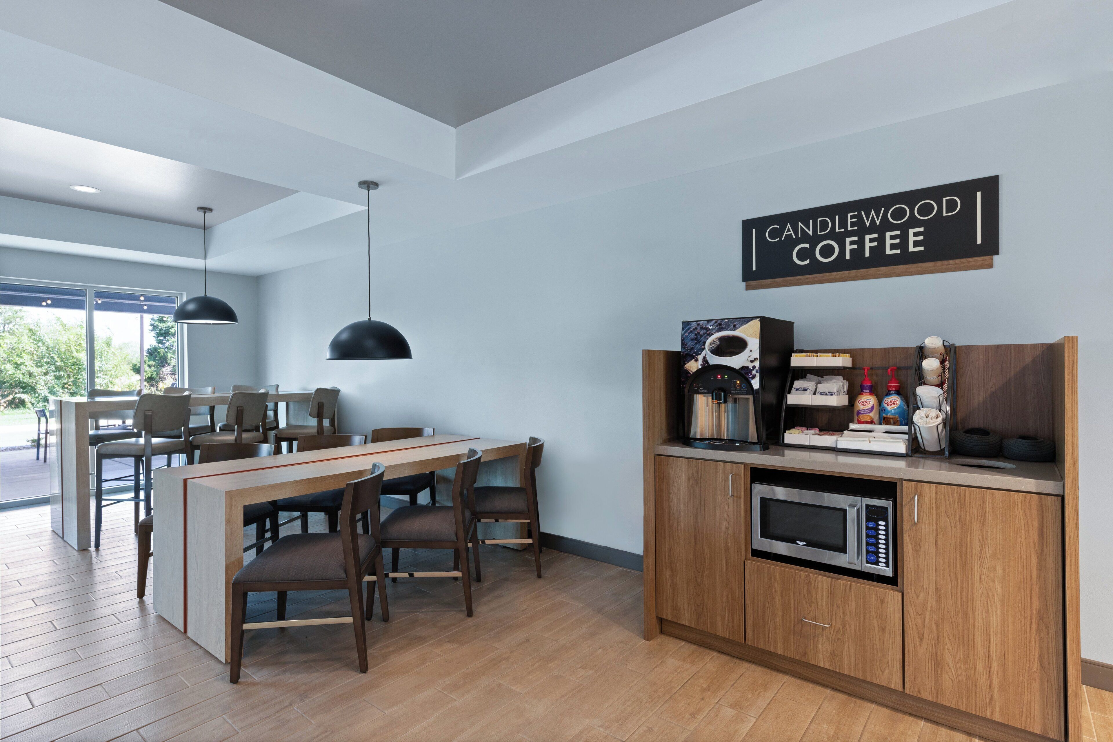 A modern kitchen with a wood cabinet, a coffee machine, and a sign that reads "CANDLEWOOD COFFEE".