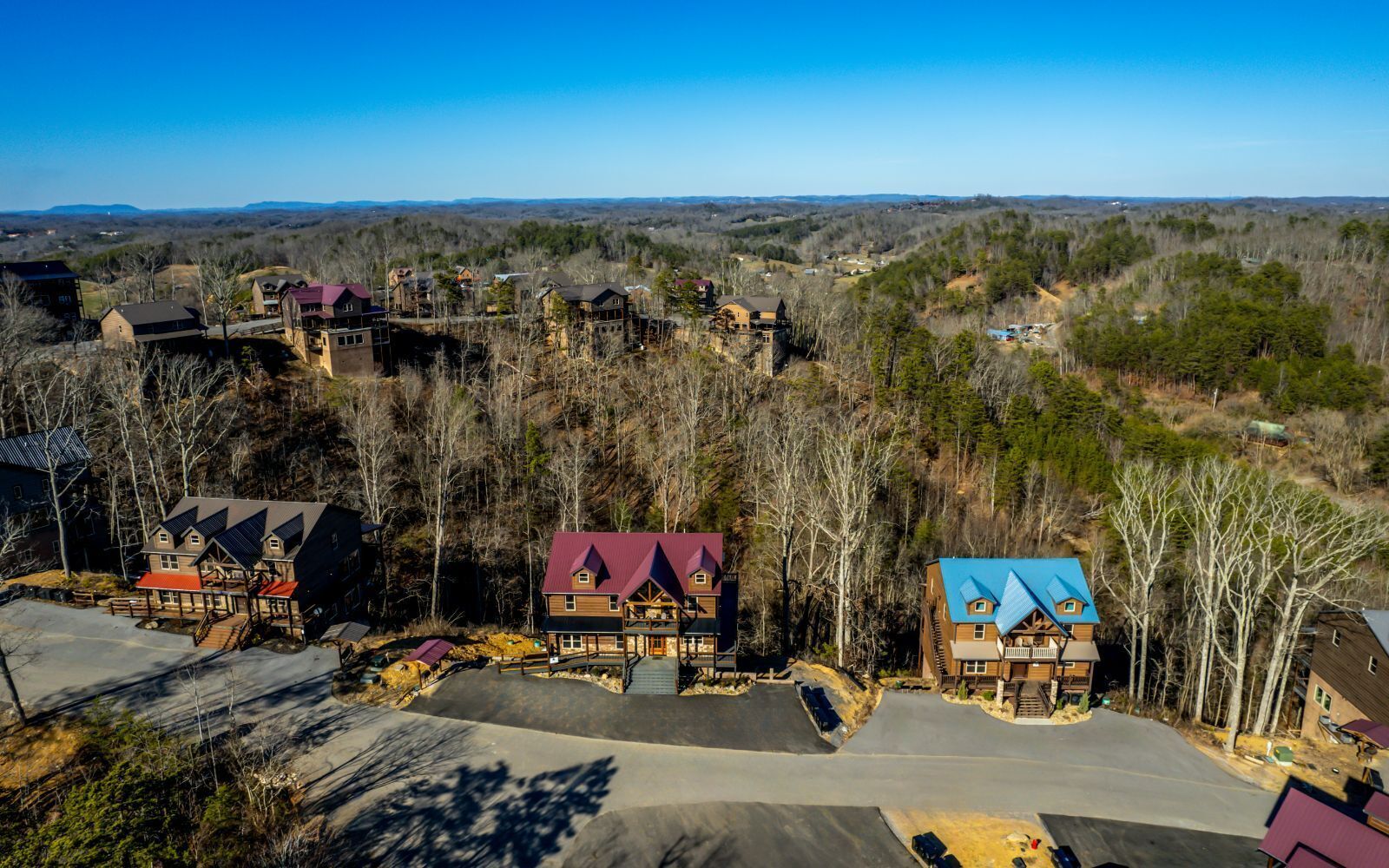 A residential area with houses featuring distinct architectural styles and a clear view of the surrounding landscape.