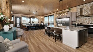 A spacious kitchen with a central island, stainless steel appliances, and a rustic wooden ceiling. - Splashin' Mountain Retreat - Sip Cocktails Fireside, Swim with Fountains & Project Movies! (Sevierville)