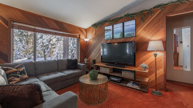A living room with a large flat-screen TV, a sofa, a coffee table, and a fireplace. - NEW - Truckee Cabin - Centrally Located (Truckee)