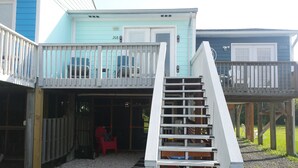 Une maison à deux étages dotée d’un balcon et d’un escalier menant à l’étage supérieur.