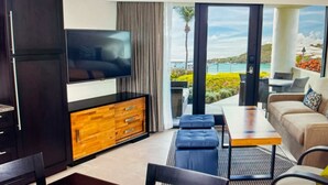 Una sala moderna con televisor de pantalla plana, mueble de madera y sofá.
