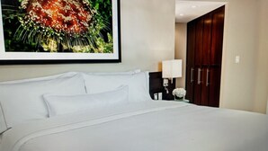 Una cama bien hecha con sábanas blancas en una habitación de hotel.