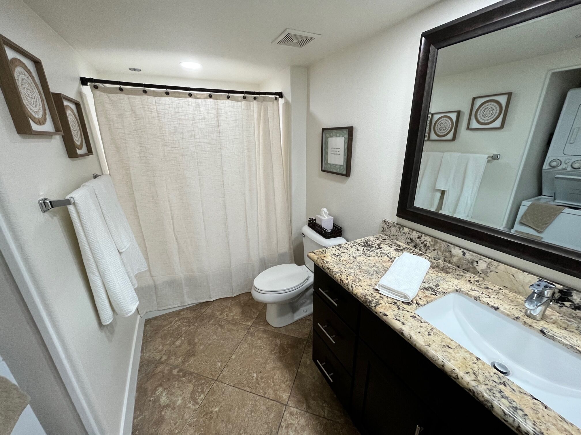 A bathroom with a toilet, sink, and shower curtain.